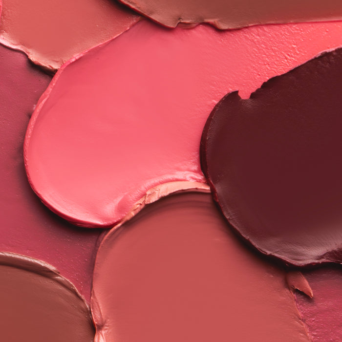 Close-up of a makeup palette with pink, red, and brown cream blushes