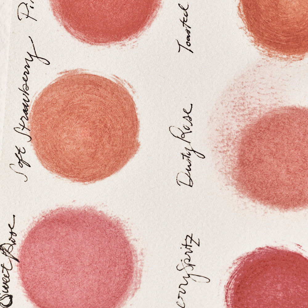 Pattern of pink blush swatches with names on a white background