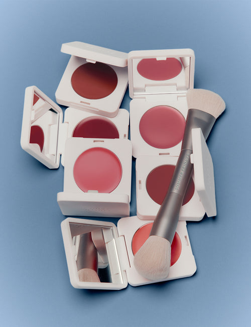 Makeup products including blushes and a brush on a blue background