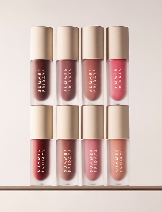 Four bottles of Summer Fridays Dream Lip Oil on a dark background