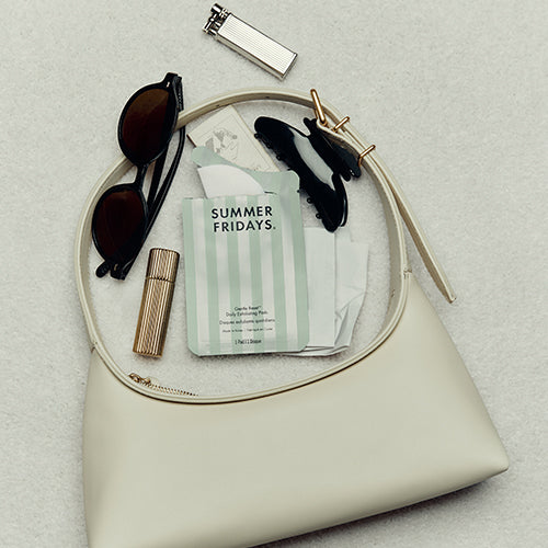 Beige handbag with sunglasses, a lighter, and a 'Summer Fridays' product on a light gray background
