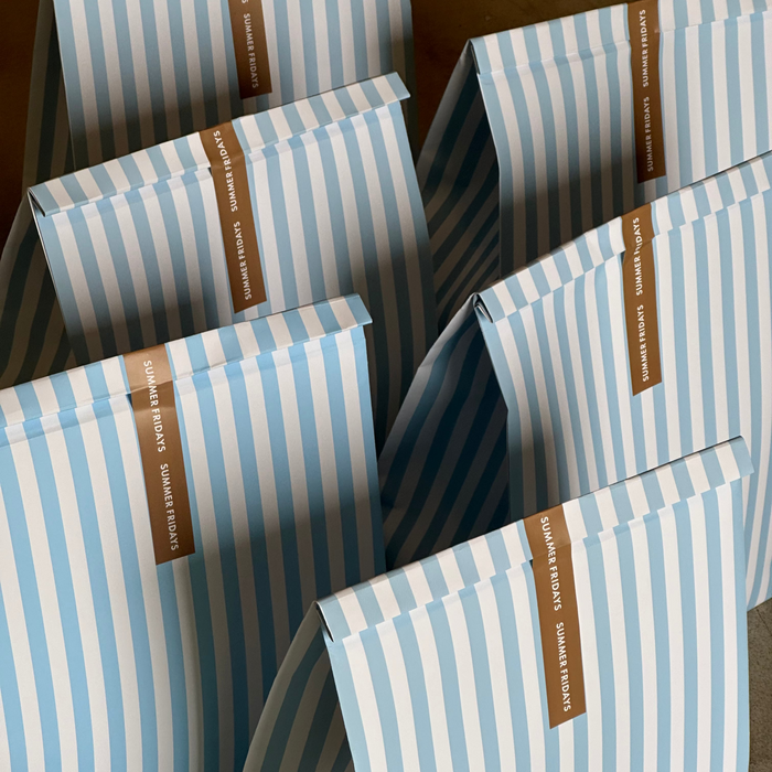 Blue and white striped packages with brown labels on a wooden surface