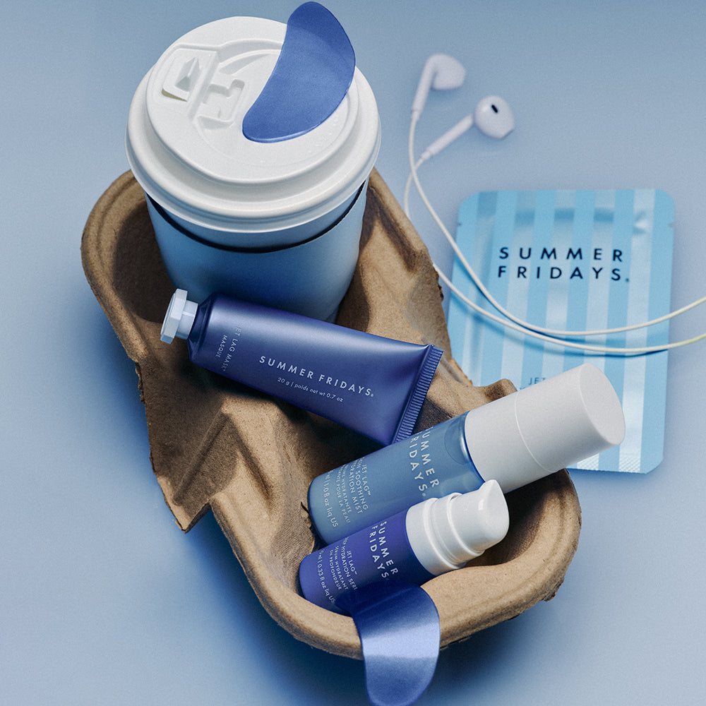 Summer Fridays skincare products and a coffee cup on a blue background