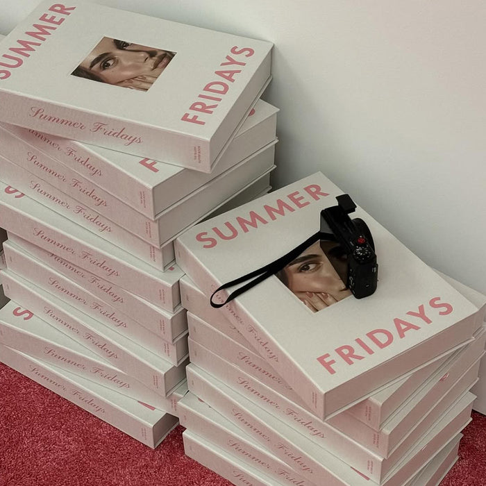 Stacks of 'Summer Fridays' books with a camera on top