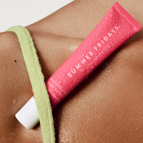 Pink 'Summer Fridays' skincare product on a person's arm with a green top