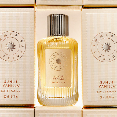 Bottle of Summer Fridays Sunlit Vanilla eau de parfum with two boxes in the background.