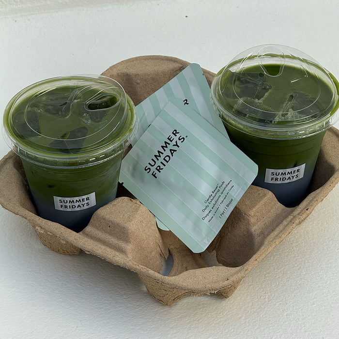 Two green Iced Matcha Lattes in clear cups with a 'Summer Fridays' card in a cardboard holder.