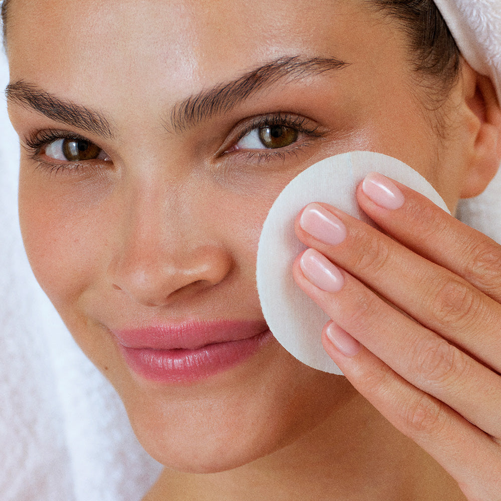Woman exfoliating her face using the Summer Fridays Gentle Reset Daily Exfoliating Pads