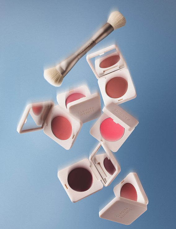 Makeup products including blushes and a brush on a blue background