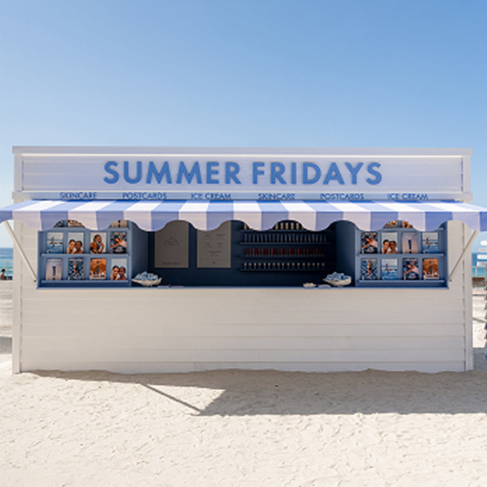 Beachside kiosk with 'Summer Fridays' sign on a clear day