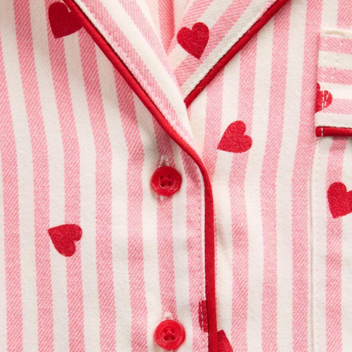 Close-up of a pink and white striped garment with red heart patterns and buttons.