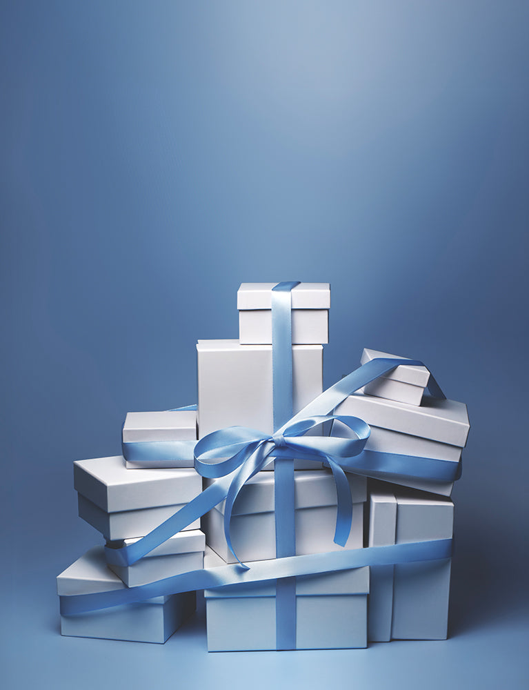 Stack of white gift boxes with blue ribbons on a blue background