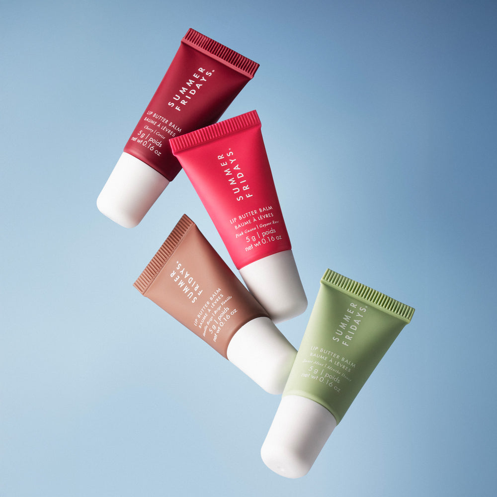 Four Summer Fridays lip balm tubes in different colors on a light blue background