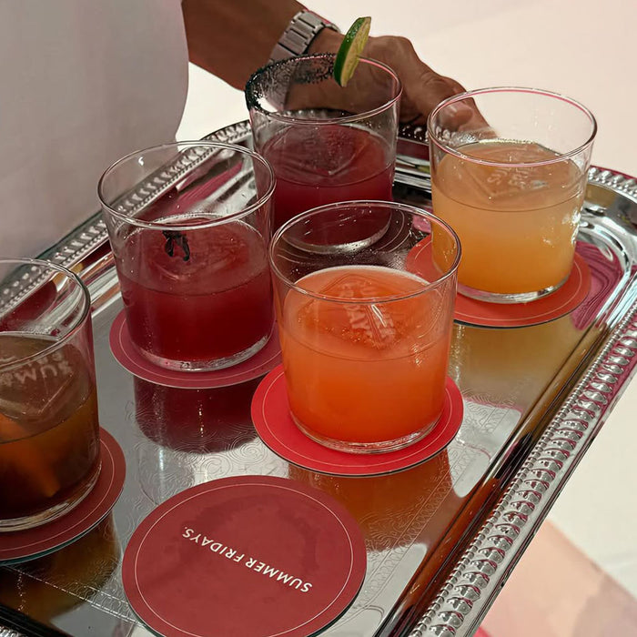 Assorted cocktails on a tray with 'Summer Fridays' coasters.