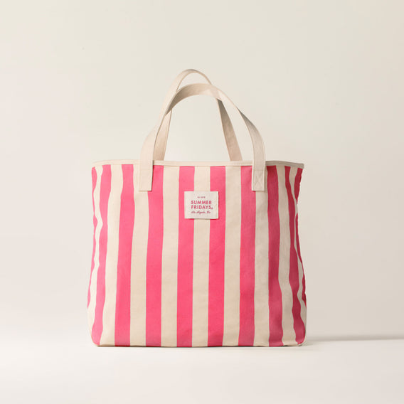 Pink and white striped tote bag with a visible brand label on a light background