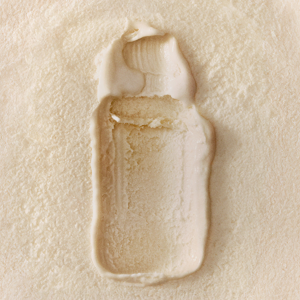 Close-up of a beige cream smear on a textured beige background